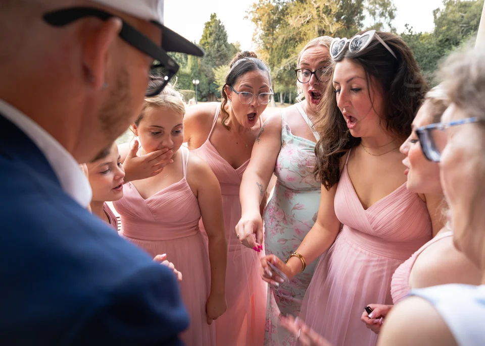 Wedding guests react as Phil performs close-up magic outdoors