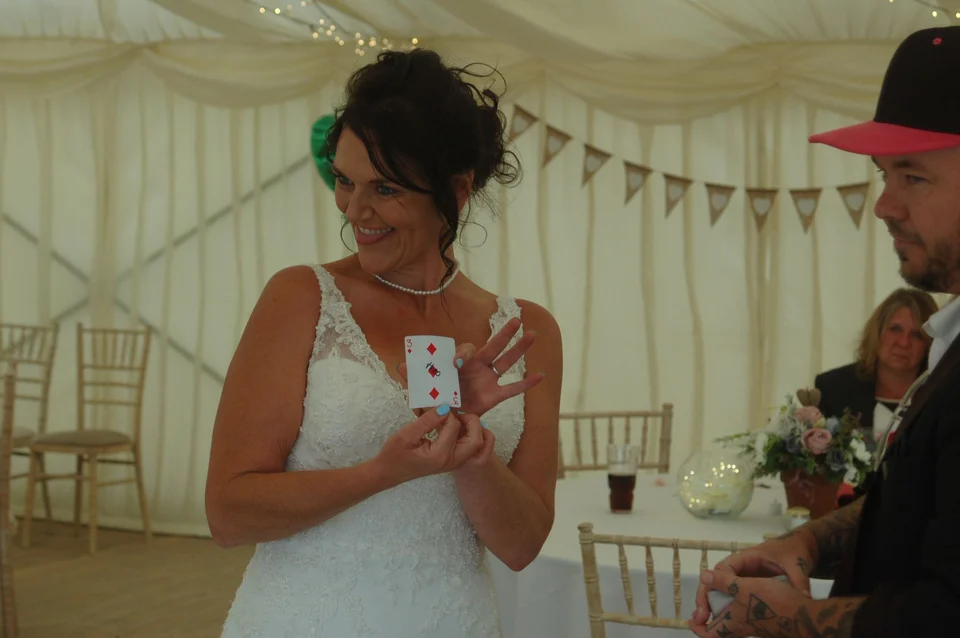 A bride holding a playing card during Phil’s performance