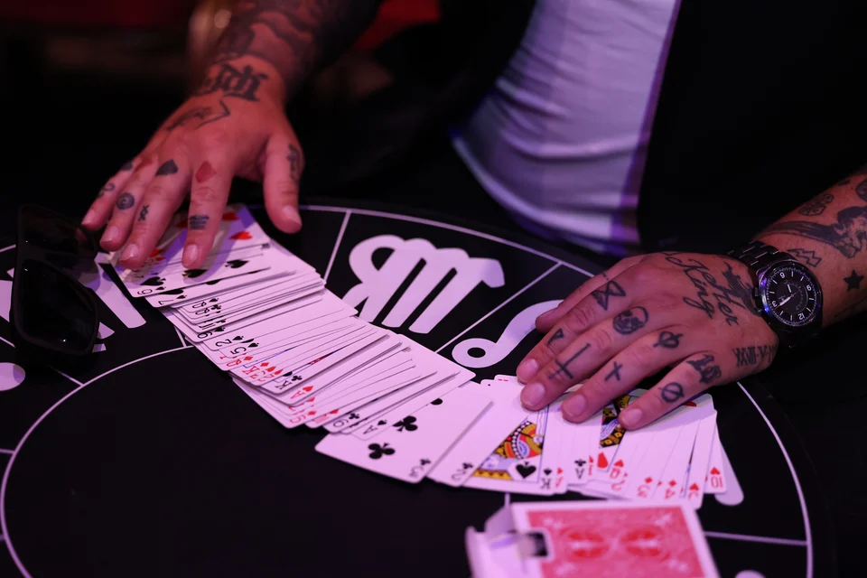 Phil’s tattooed hands spreading a deck of cards