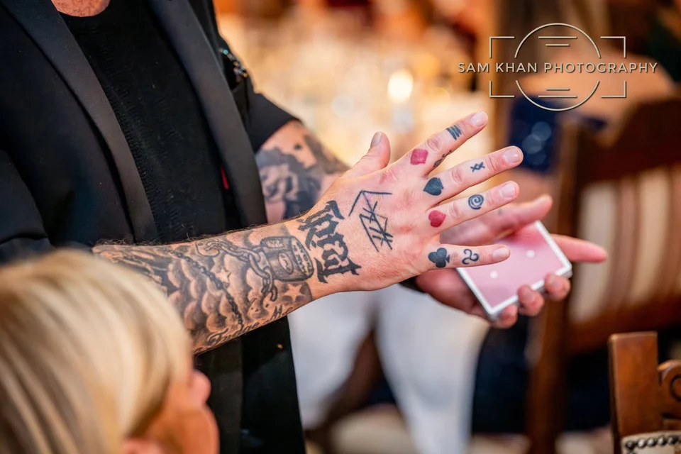 Close-up of Phil’s tattooed hands during a card trick