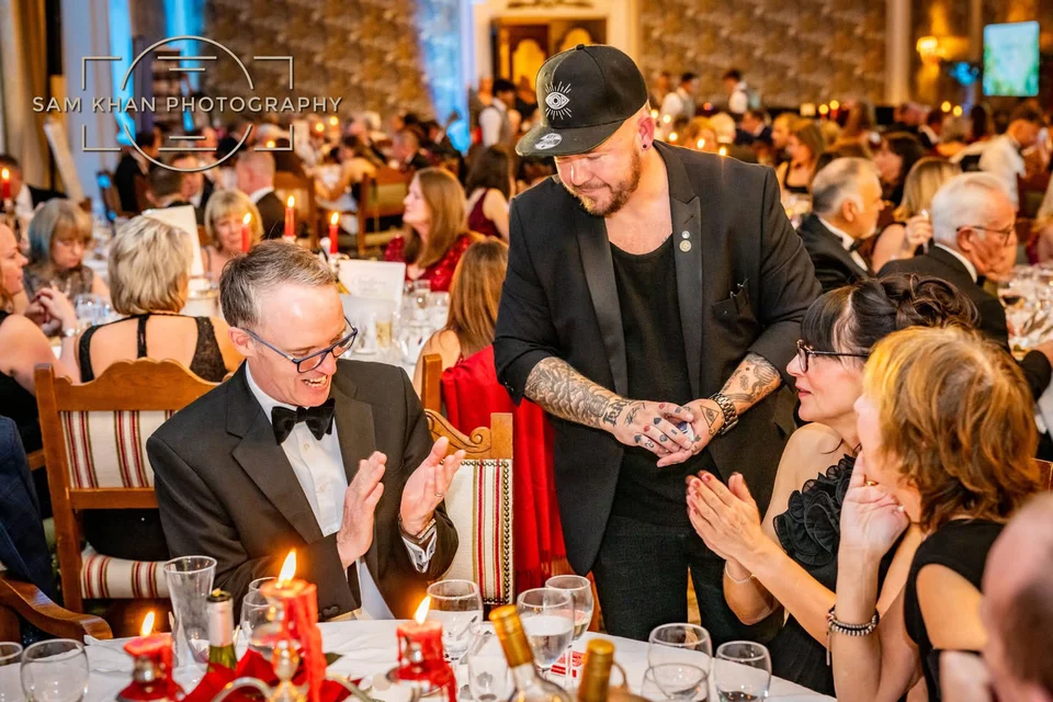 Phil performing card magic for guests at a corporate dinner