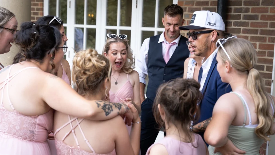 Wedding guests reacting in surprise as Phil performs close-up magic