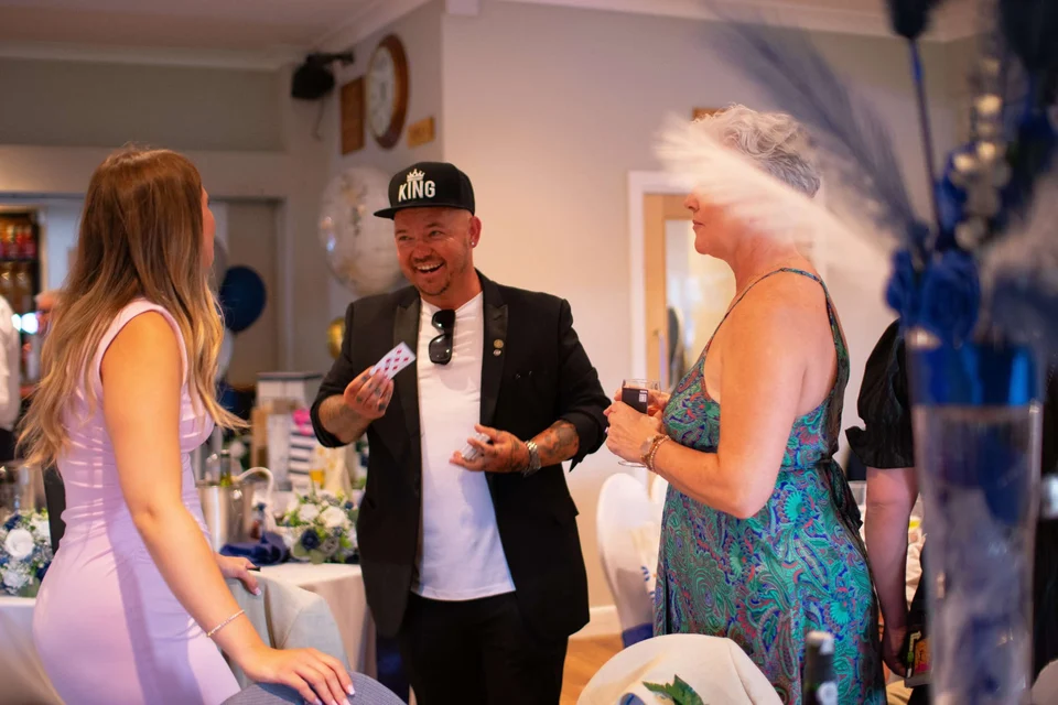 Phil laughing with guests at a wedding reception