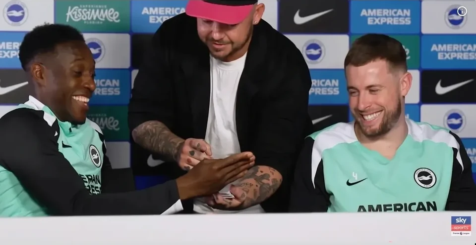 Phil Pearson performing close-up magic for Danny Welbeck and a Brighton player
