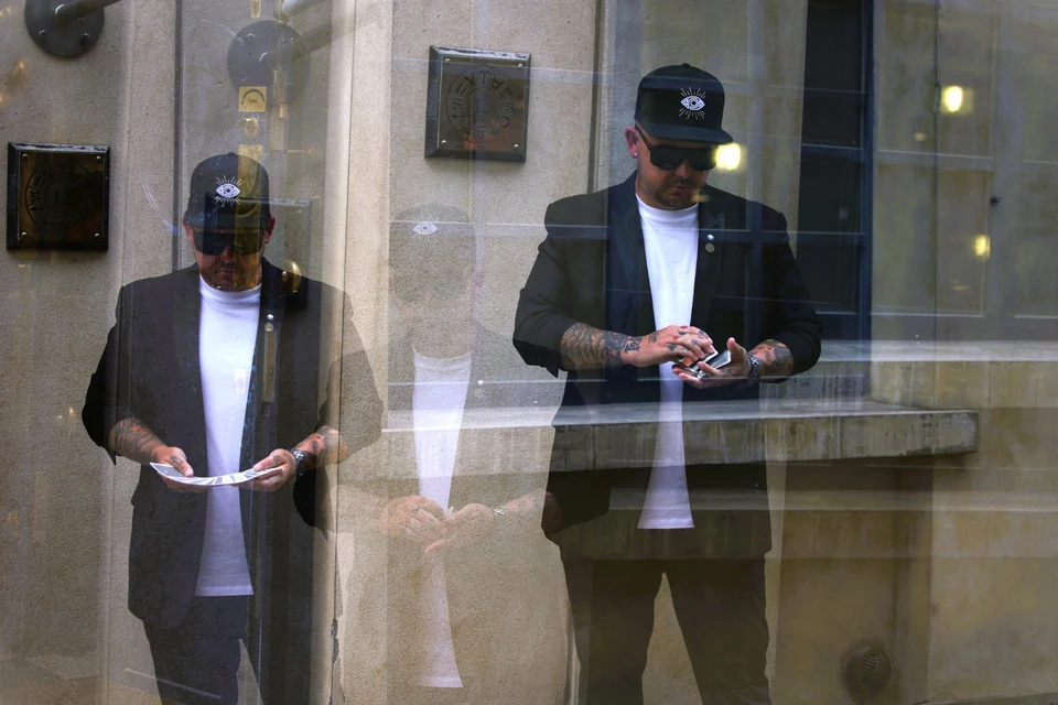 Phil Pearson performing card magic in a double-exposure editorial portrait