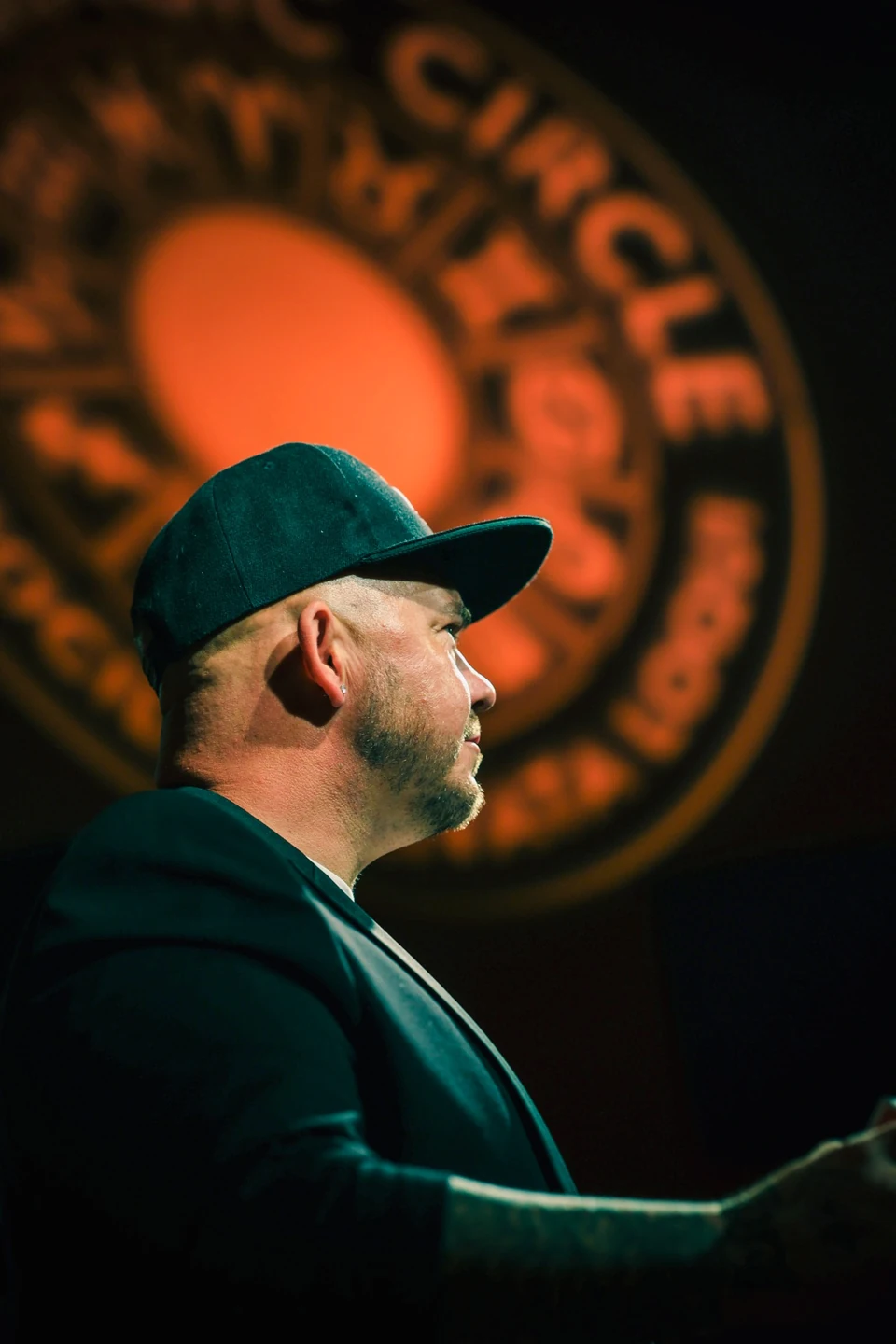 Phil Pearson in profile with The Magic Circle emblem behind him