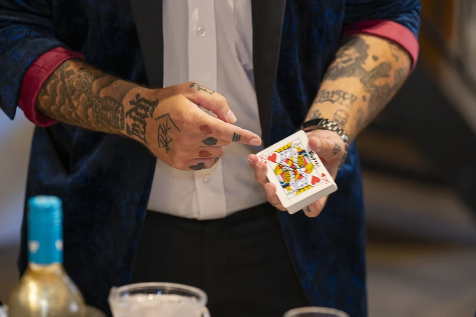Phil Pearson’s tattooed hands performing card magic at a wedding