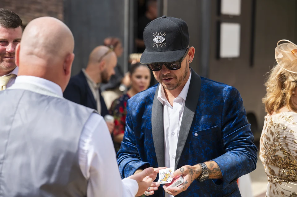 Phil Pearson performing close-up magic outdoors for wedding guests